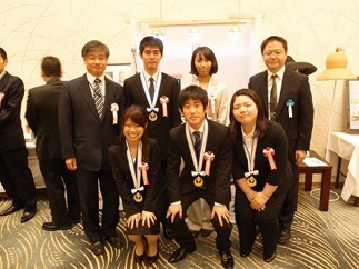 ものづくり日本大賞受賞作品をバックに、松林教授（後列右端）常盤大臣官房審議官（後列左端）、学生の皆さん